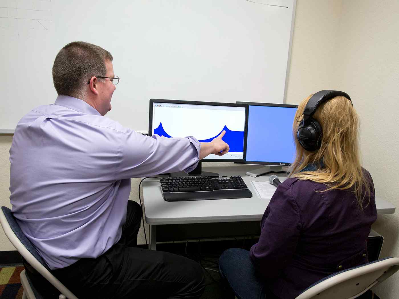 Audiology students studying an audio waveform on a computer screen. 