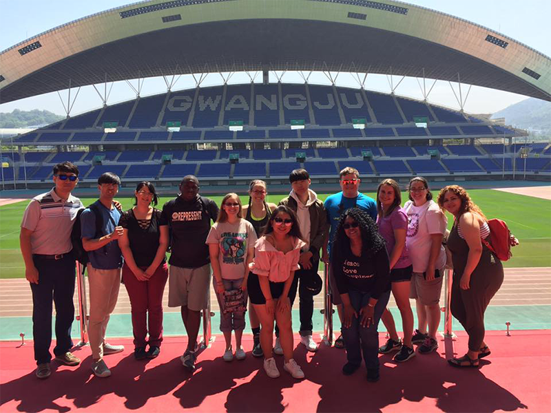 A group of students poses at a stadium